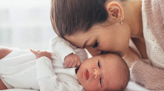 A woman kissing a baby in the head