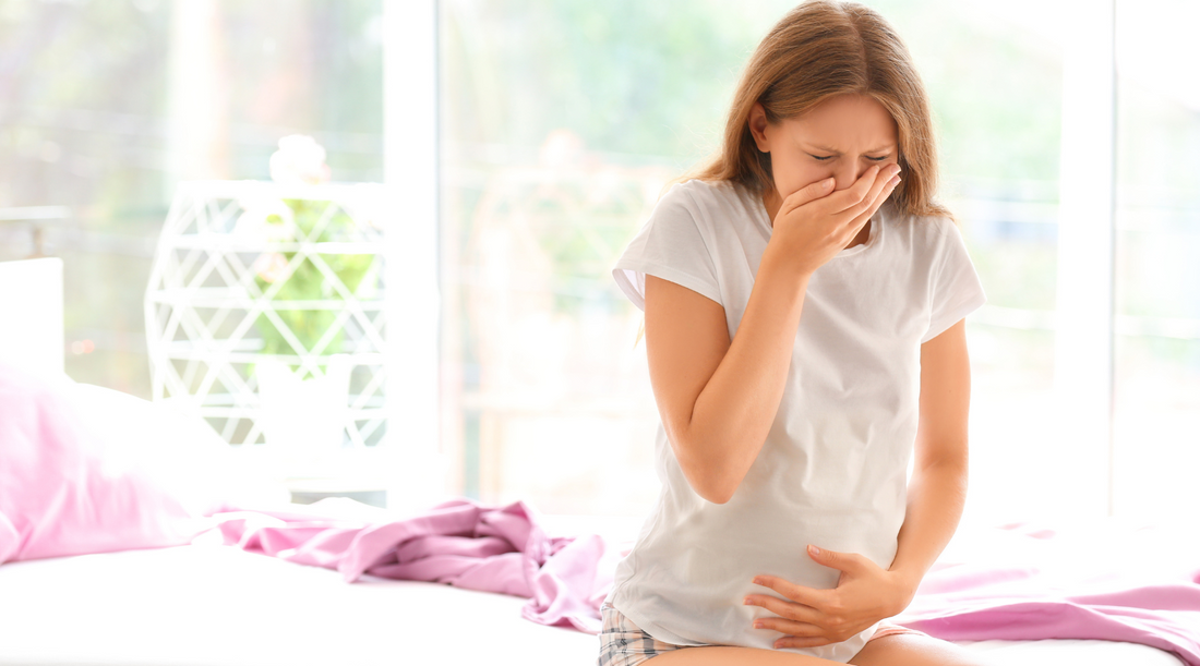 a pregnant covering her mouth because of morning sickness