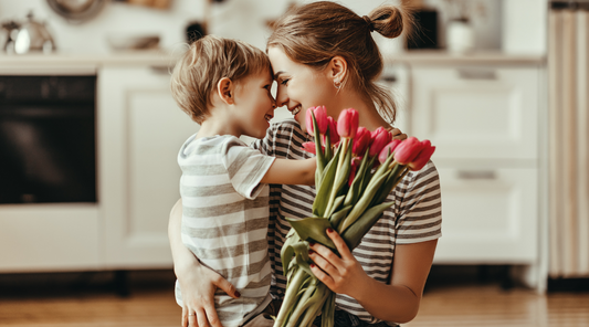 baby boy hugging her mom with tulips flowers for mothers day