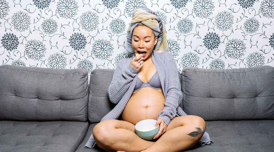 a person sitting on a couch eating a bowl of cereal